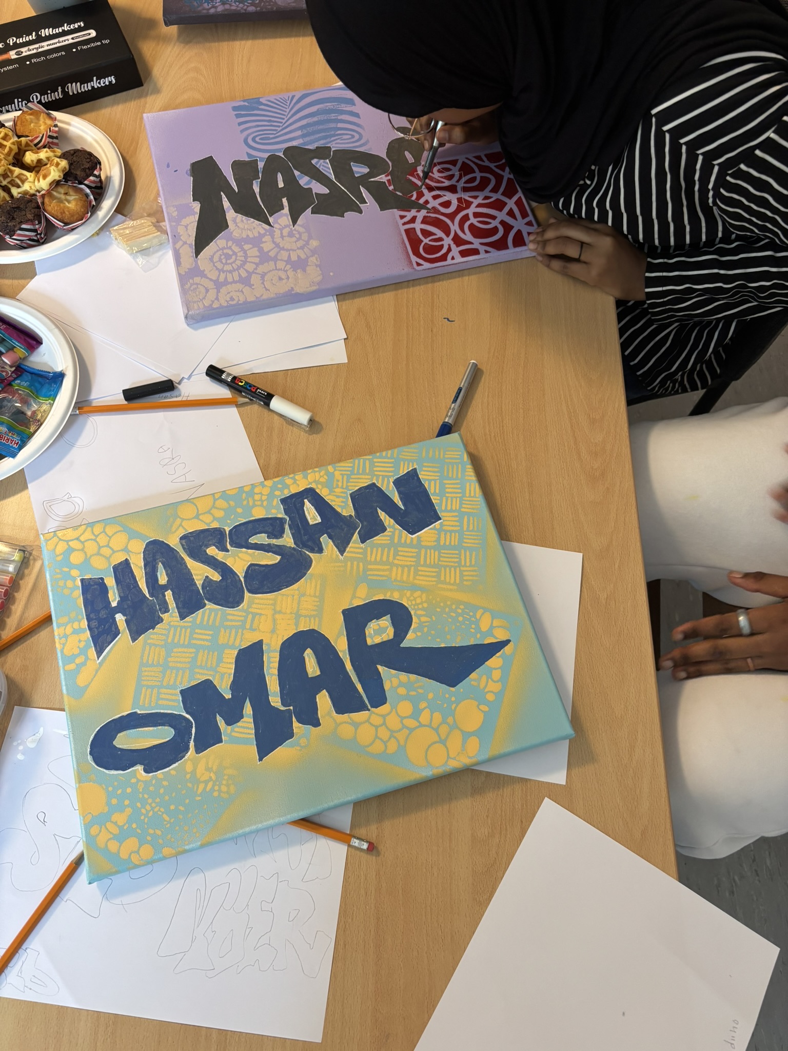 Jugendliche entwerfen Schriftzüge und Motive auf Papier im Graffiti-Workshop von block-farbenkunst
