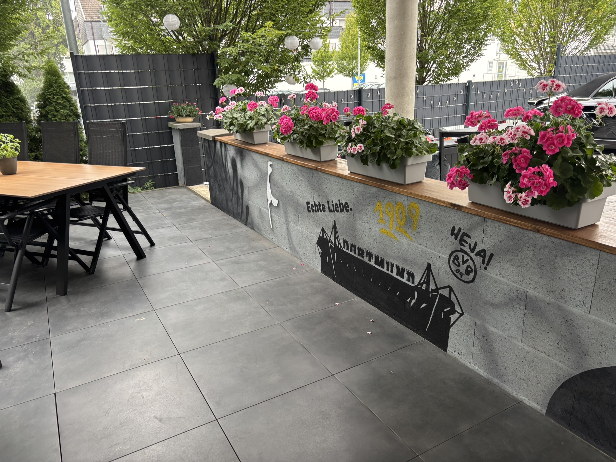 Graffiti-Gartenmauer in Attendorn mit BVB-Stadion, Sylt-Motiv und Hund – individuelle Wandgestaltung von block-farbenkunst